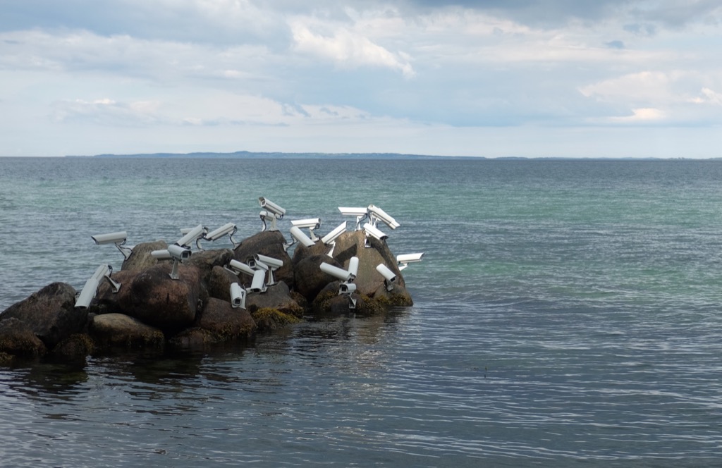 Security cameras perching on a seaside rock, like they were seagulls